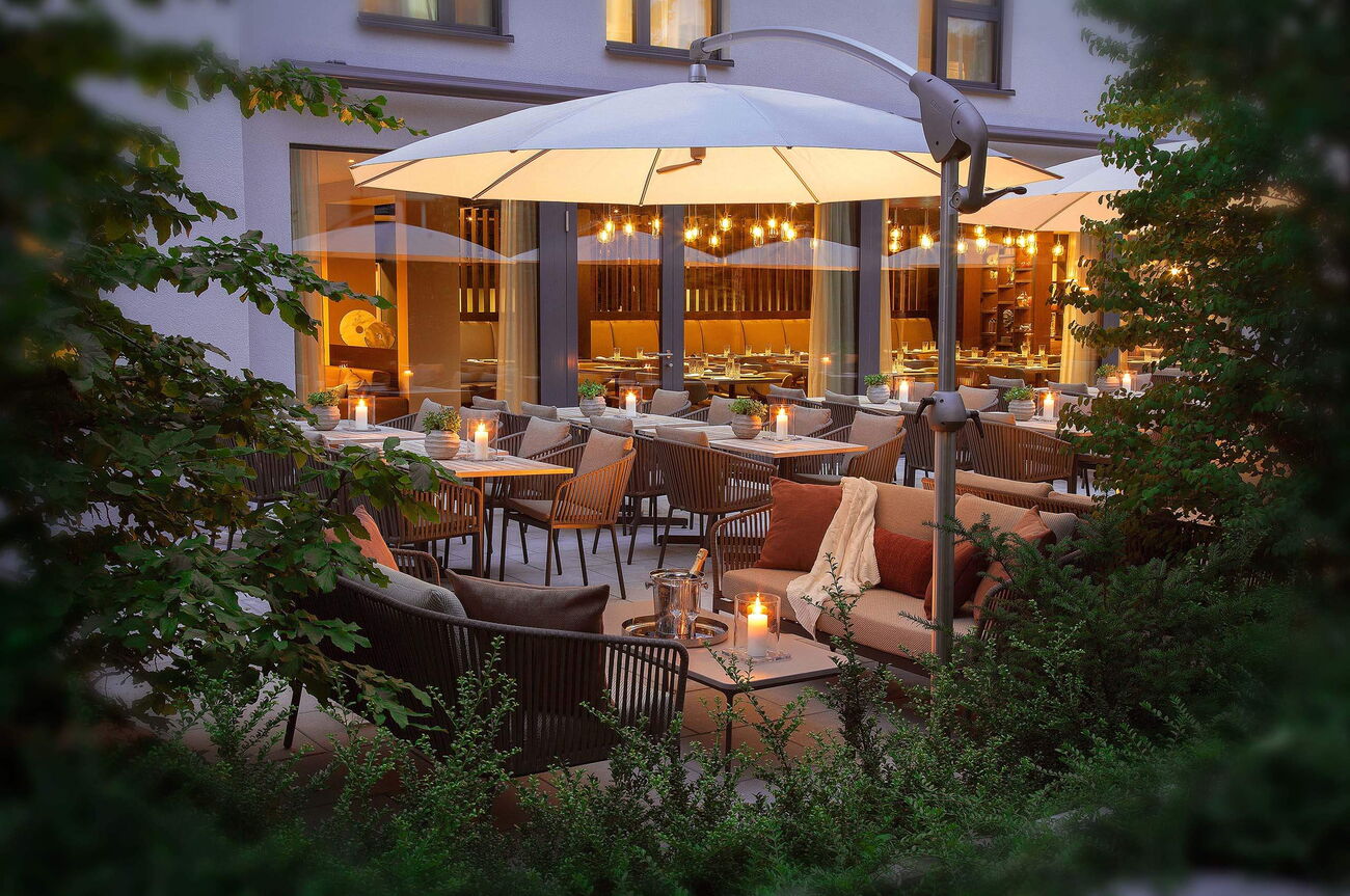 Restaurant de Jardin à l'hôtel Acasa Suites à Zurich Oerlikon avec une atmosphère romantique à la lumière des bougies
