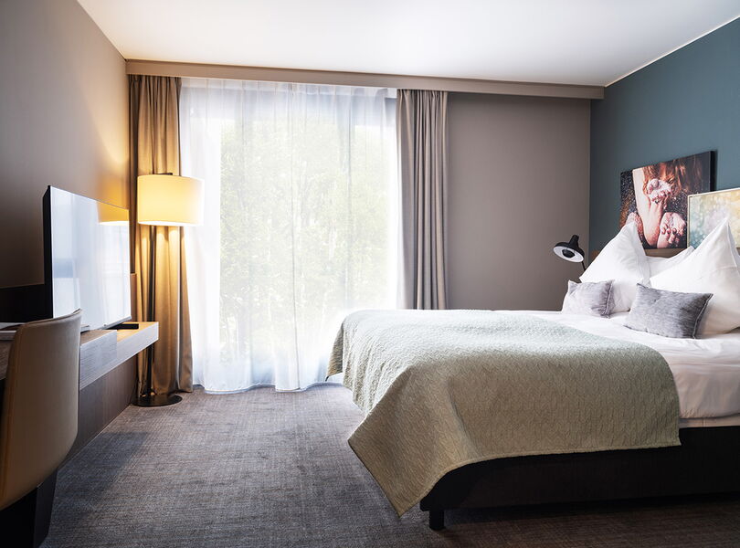 Basic Suite: Schlafzimmer mit King-Size-Bett im Acasa Suites Zürich