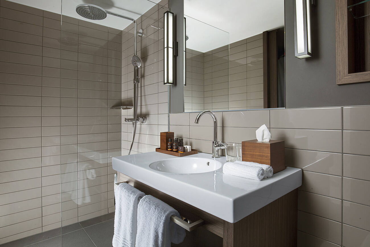 Salle de bain avec douche à effet pluie dans les appartements ACASA Suites Zurich